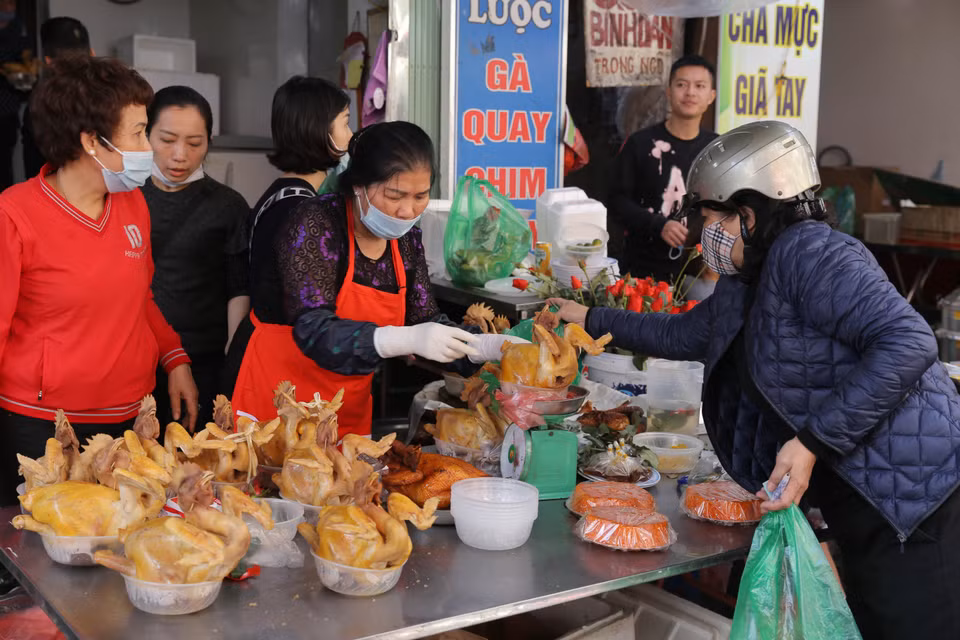 Chợ Hàng Bè là nơi nhiều người dân thủ đô chọn mua những con gà luộc sẵn, buộc cánh tiên, ngậm hoa thật đẹp để cúng tất niên và Giao thừa. (Ảnh: Hoàng Hiếu/TTXVN)