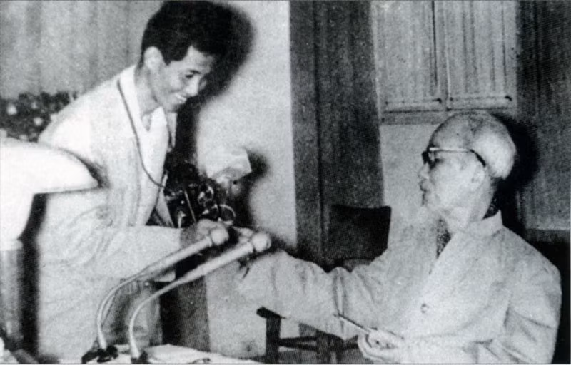 Chủ tịch Hồ Chí Minh tặng thuốc lá thơm cho nhà báo Lâm Hồng Long - tác giả của bức ảnh nổi tiếng Bác bắt nhịp Bài ca Kết đoàn. (Ảnh: Tư liệu TTXVN)