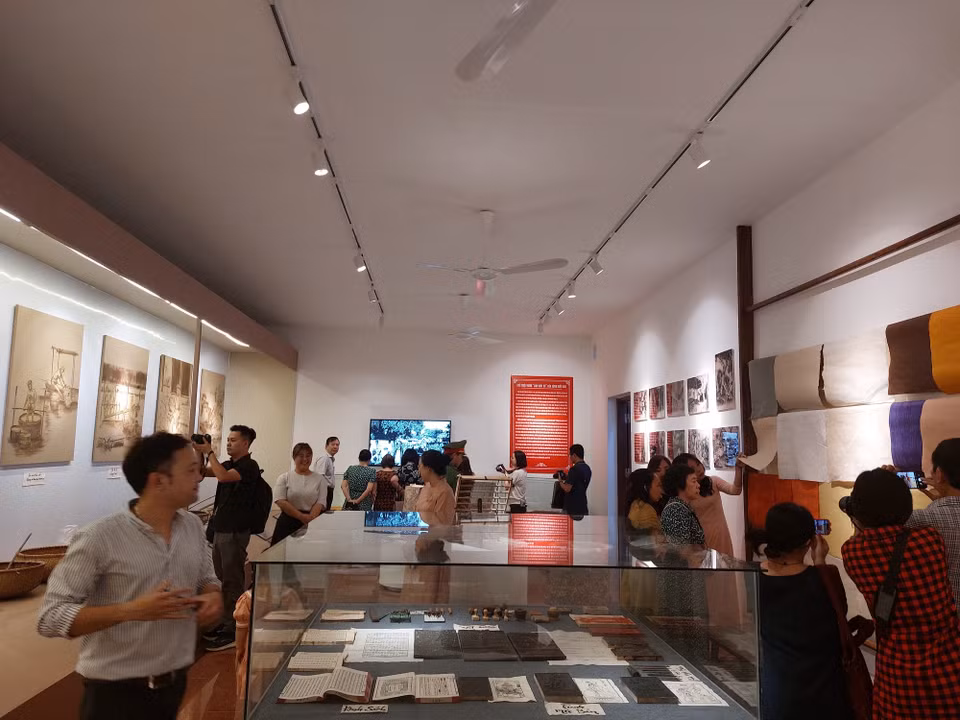 Du khách tham quan không gian trưng bày giới thiệu nghề giấy Dó vùng Bưởi. (Ảnh: Minh Ngọc/TTXVN phát)