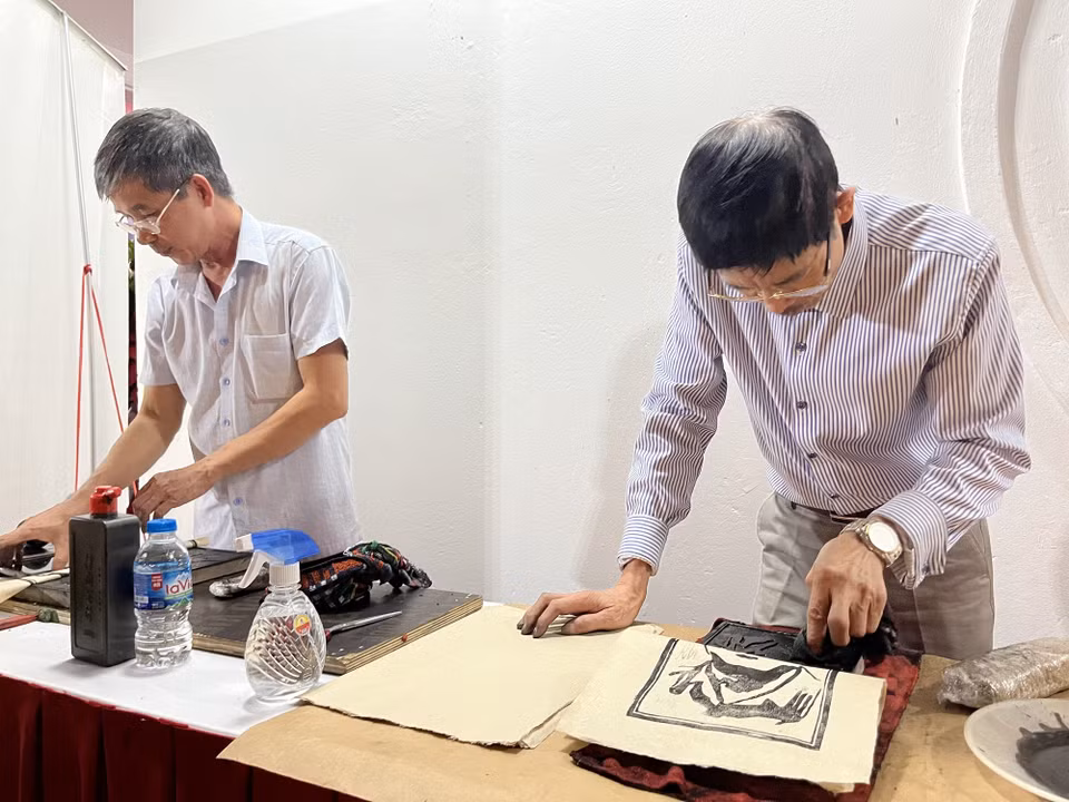 Thực hiện công đoạn in tranh trên giấy Dó. (Ảnh: Minh Ngọc/TTXVN phát)