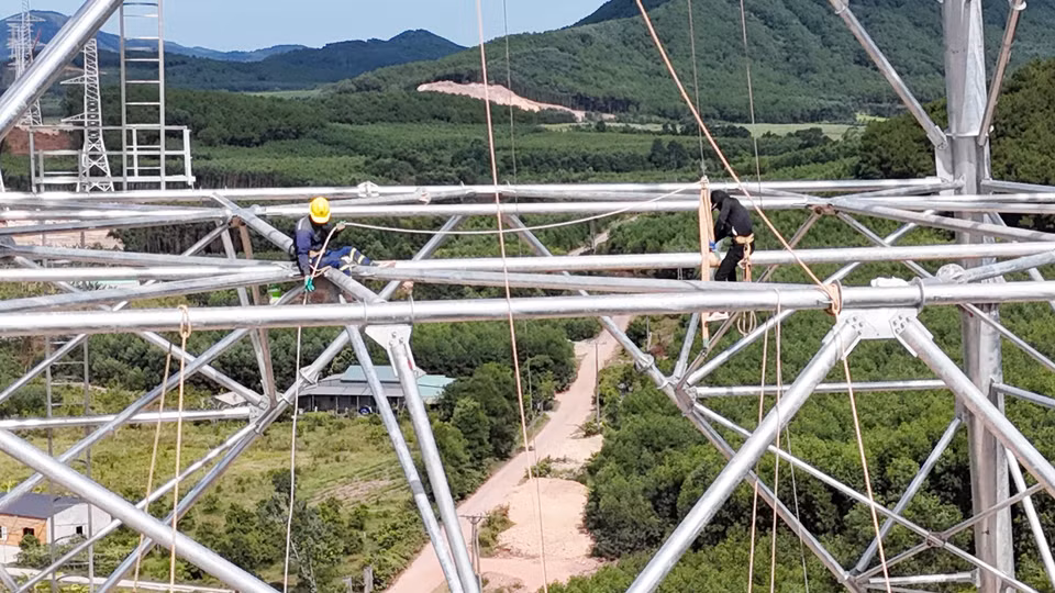 Công nhân thuộc Công ty Cổ phần tập đoàn PC1 Hà Nội khẩn trương hoàn thành các hạng mục cuối tại vị trí cột 135. (Ảnh: Hữu Quyết/TTXVN)