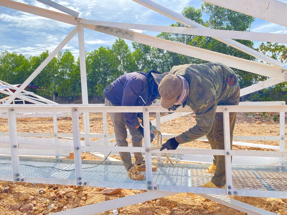 Công nhân bắt đai ốc hệ thống xà của cột 135. (Ảnh: Hữu Quyết/TTXVN)