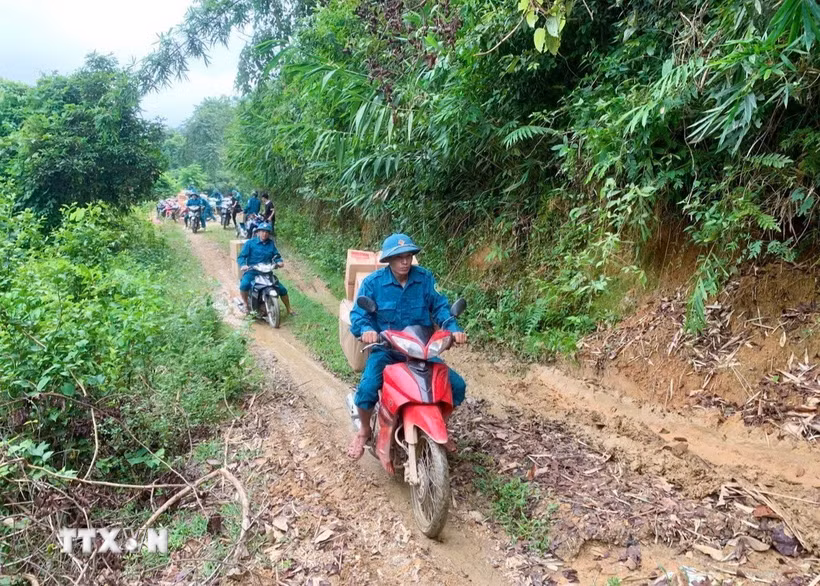 Hành trình chở lương thực, thực phẩm, nhu yếu phẩm bằng xe máy xuyên đại ngàn Pù Huống vào hỗ trợ cho bà con dân bản Na Ngân. (Ảnh: TTXVN phát)