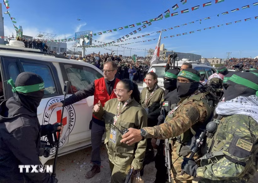 Các thành viên Lữ đoàn Al-Qassam và Al-Quds tiến hành lễ trao trả 4 nữ binh sĩ Israel cho Ủy ban Chữ thập đỏ quốc tế (ICRC) tại thành phố Gaza, ngày 25/1/2025. (Ảnh: AA/TTXVN)