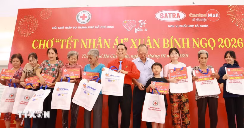Đại diện Hội Chữ thập đỏ Thành phố Hồ Chí Minh tặng quà cho các gia đình khó khăn tại sự kiện Chợ Tết Nhân ái Xuân Bính Ngọ 2026. (Ảnh: Đinh Hằng/TTXVN)