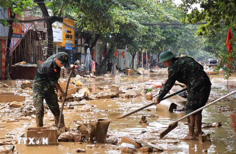 Cán bộ, chiến sỹ Bộ chỉ huy Quân sự tỉnh Lào Cai giúp đỡ người dân vùng ngập lụt khắc phục hậu quả sau bão. (Ảnh: Đinh Thùy/TTXVN)