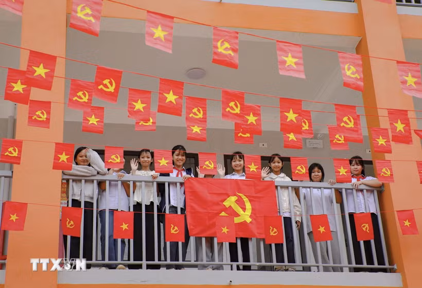 Học sinh Trường Phổ thông nội trú Tiểu học và THCS Sam Mứn tươi vui bên những lá cờ Đảng, cờ Tổ quốc được trang trí trên hành lang. (Ảnh: Xuân Tư/TTXVN)