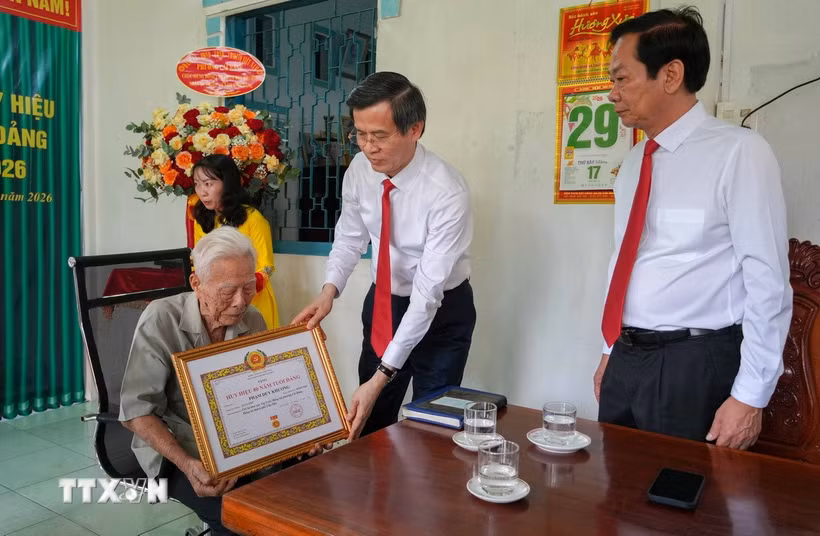 Ông Đoàn Minh Huấn, Ủy viên Bộ Chính trị, Giám đốc Học viện Chính trị Quốc gia Hồ Chí Minh trao chứng nhận 80 năm tuổi Đảng cho đảng viên Phạm Duy Khương. (Ảnh: Thanh Liêm/TTXVN)