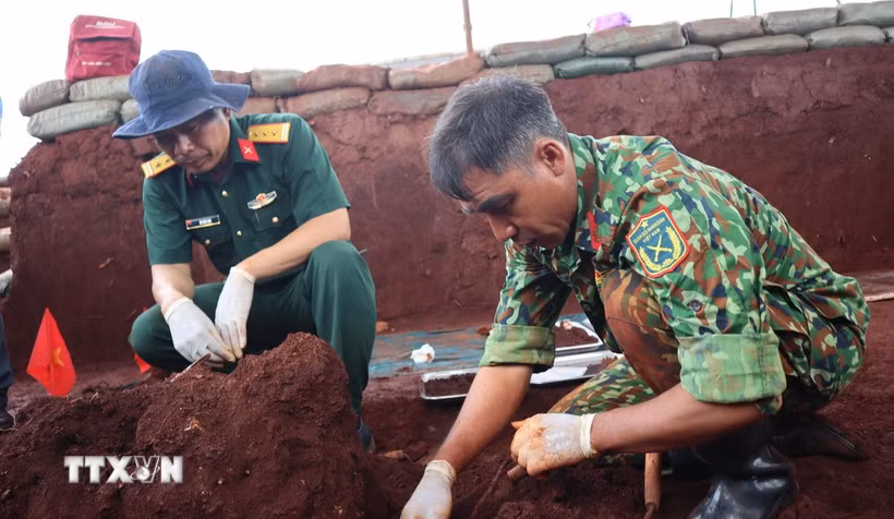 Lực lượng chức năng tìm kiếm, quy tập hài cốt liệt sỹ tại xã Minh Đức, thành phố Đồng Nai. (Ảnh: Đậu Tất Thành/TTXVN)
