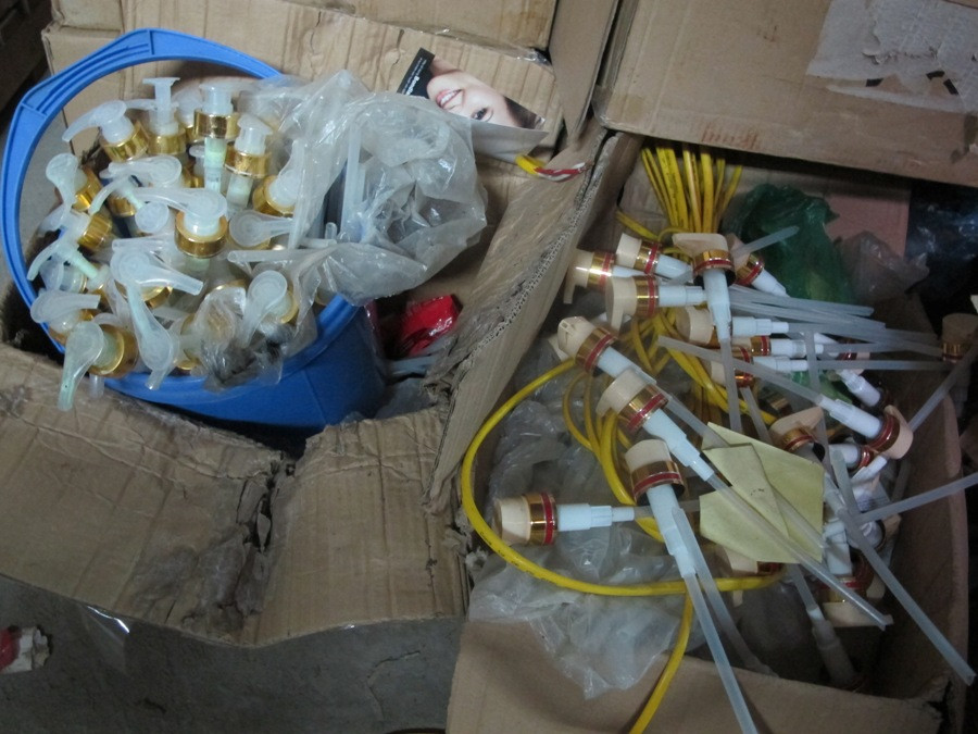 Lực lượng chức năng còn phát hiện cả vỏ chai và nhãn phụ tự in (Ảnh: Đức Duy/Vietnam+)