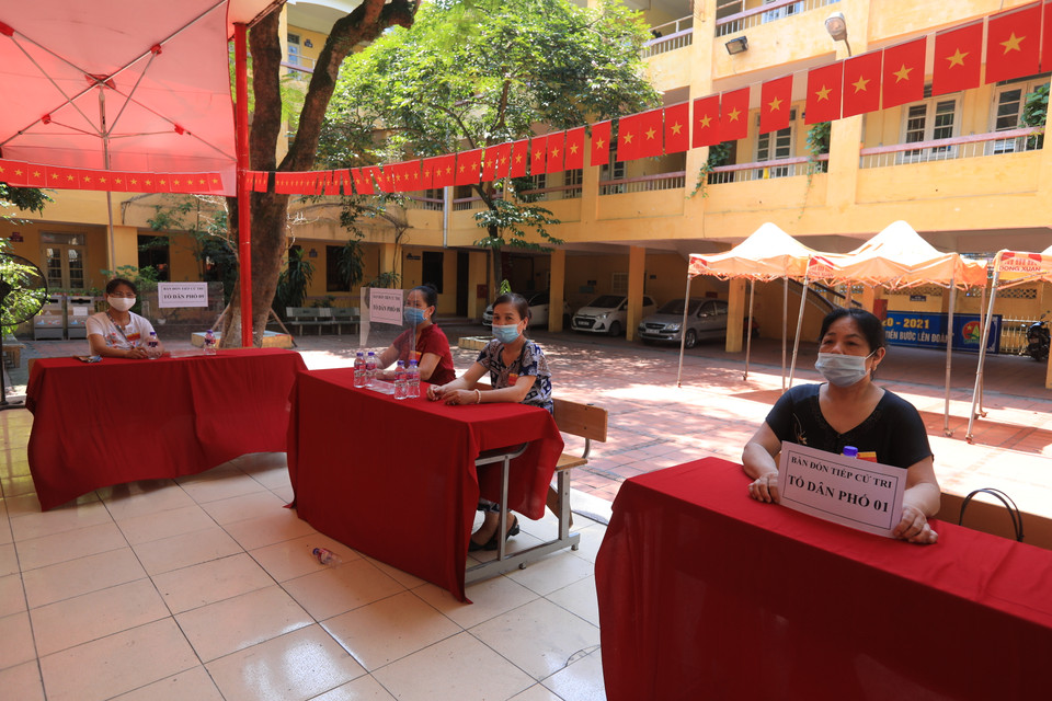Tại các bàn đón tiếp cử tri đều có cán bộ của tổ bầu cử hướng dẫn các quy trình bỏ phiếu. (Ảnh: Xuân Quảng/Vietnam+)