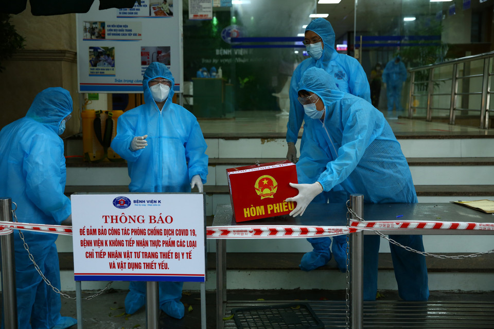 Nhân viên Tổ bầu cử thực hiện các quy trình tiếp nhận hòm phiếu. (Ảnh: Xuân Quảng/Vietnam+)