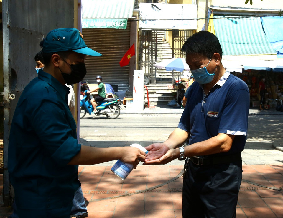 Tại Khu vực bỏ phiếu số 1, Phường Đồng Xuân, quận Hoàn Kiếm, các cán bộ y tế thực hiện các biện pháp về phòng dịch cho người dân đến bỏ phiếu. (Ảnh: Xuân Quảng/Vietnam+)