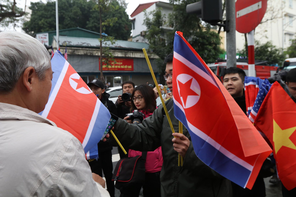 Quốc kỳ Triều Triên được các bạn trẻ chuyền tay nhau cùng với quốc kỳ Việt Nam và Hoa Kỳ. (Ảnh: Minh Sơn/Vietnam+)