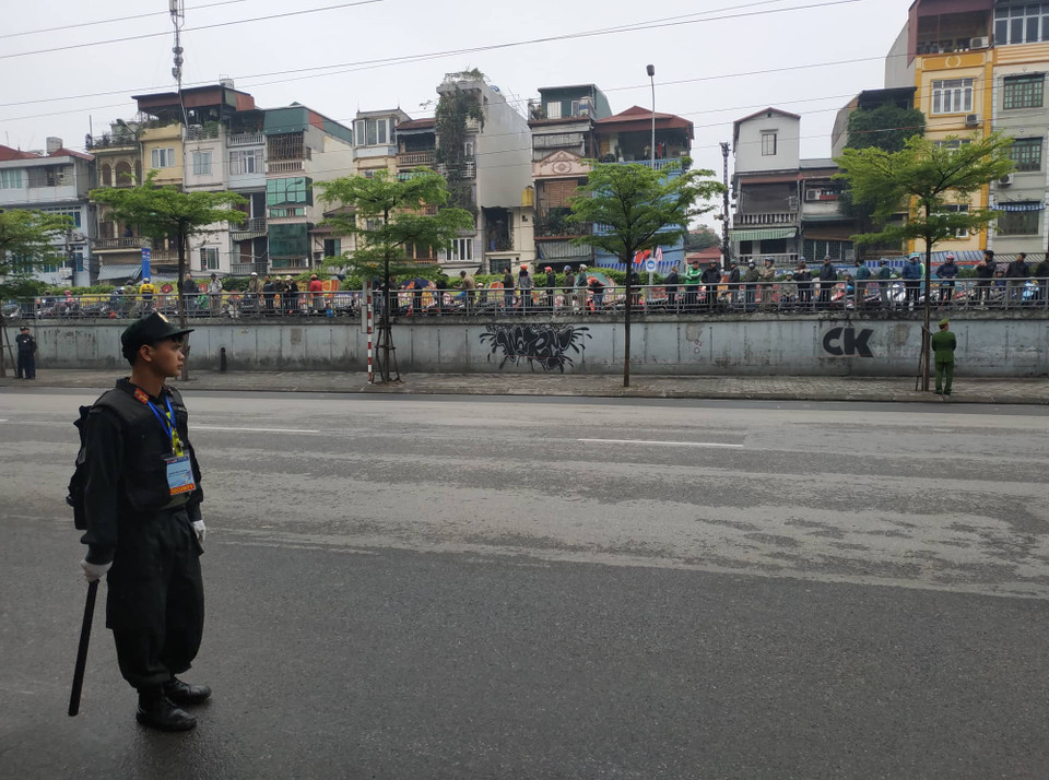 Hàng nghìn người dân đã đứng dọc hai bên đường Trần Quang Khải, tay cầm cờ và hoa để đợi đoàn xe qua. (Ảnh: Sơn Bách/Vietnam+)