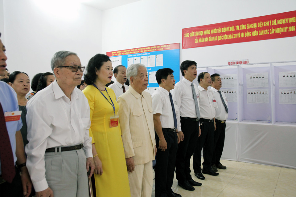 Các cử tri thực hiện nghi thức chào cờ trước khi tiến hành bầu cử. (Ảnh: Doãn Đức/Vietnam+)