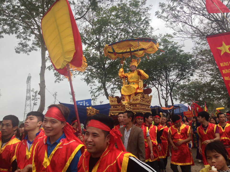 Vua giả ngồi trên kiệu được trai tráng trong làng rước ra đình cùng các quan. (Ảnh: Khánh Ly/Vietnam+)