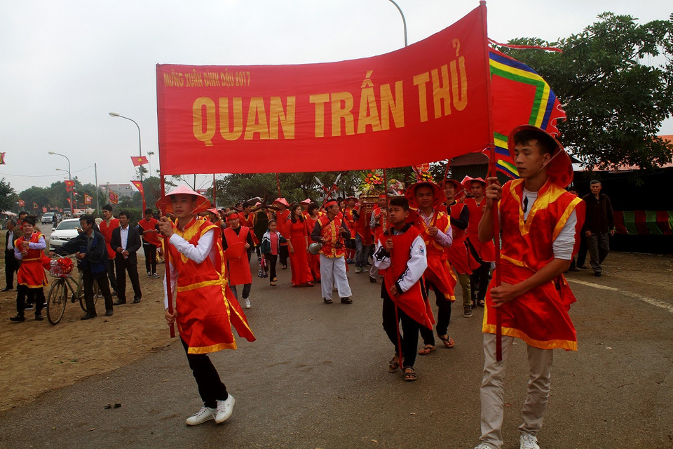 Già trẻ gái trai trong làng đều sắm cho mình một vai trong đoàn người rước kiệu. (Ảnh: Khánh Ly/Vietnam+)