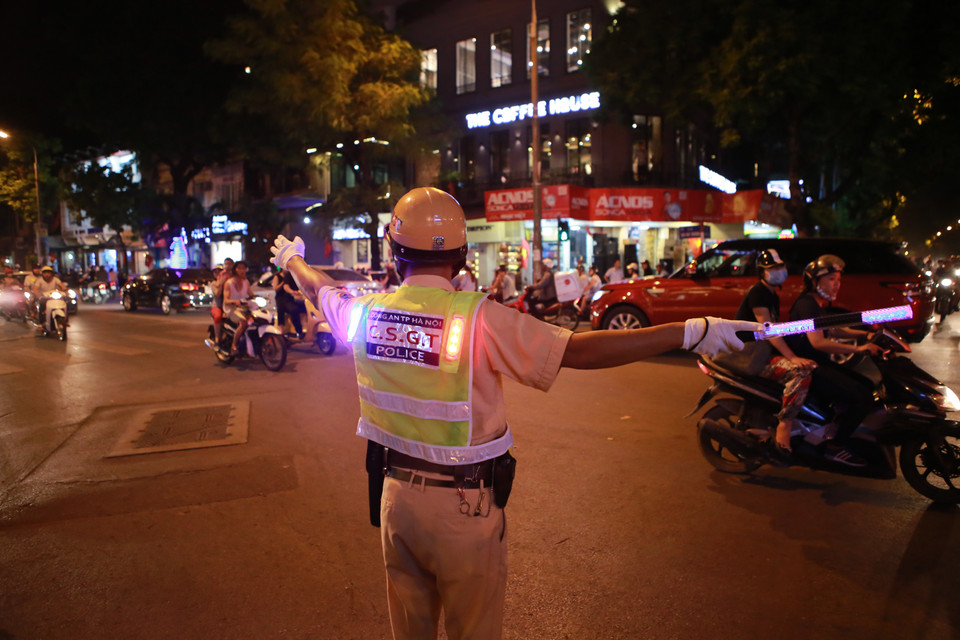 Một chiến sỹ thuộc phòng Cảnh sát giao thông Hà Nôi đang điều khiển giao thông gần tuyến phố đi bộ. (Ảnh: Minh Sơn/Vietnam+)