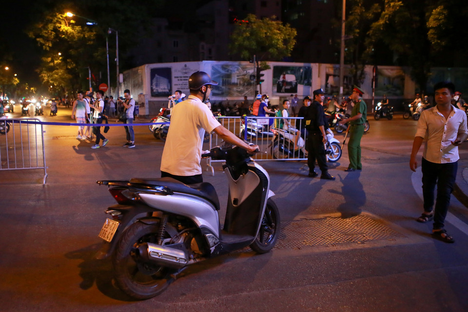 Những người dân trong khu vực cấm đường muốn về nhà phải dắt bộ xe và trình thẻ xe do thành phố phát. (Ảnh: Minh Sơn/Vietnam+)