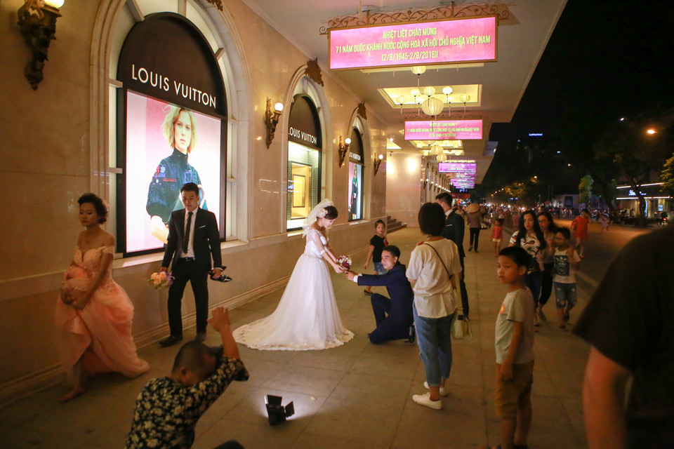Nhiều đôi bạn trẻ đang chụp ảnh cưới trong buổi tối đầu tiên thực hiện tuyến phố đi bộ. (Ảnh: Minh Sơn/Vietnam+)