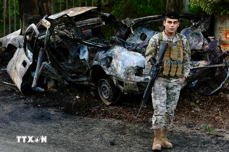 Binh sỹ Liban gác tại hiện trường vụ không kích của Israel nhằm vào chiếc xe chở thành viên lực lượng Hezbollah ở Sidon, miền Nam Liban. (Ảnh: THX/TTXVN)