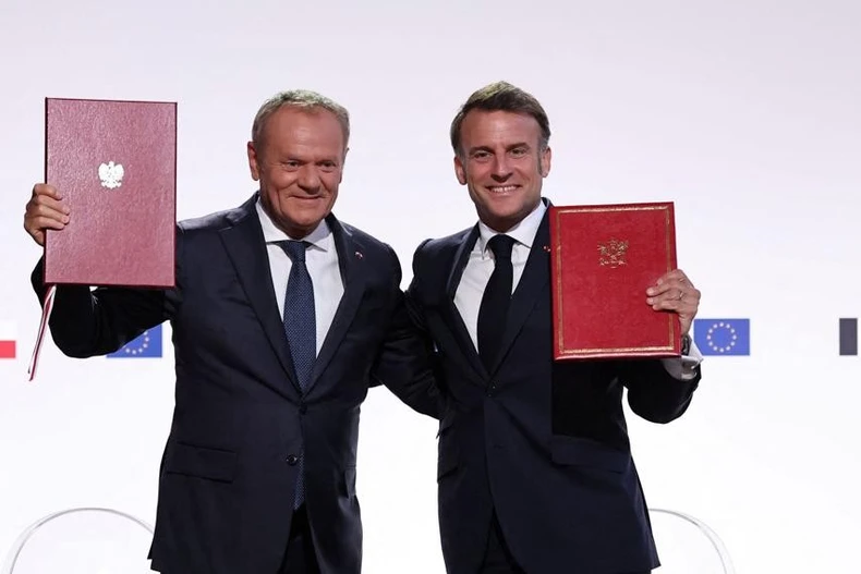 Tổng thống Pháp Emmanuel Macron (phải) và Thủ tướng Ba Lan Donald Tusk ký hiệp ước hợp tác và hữu nghị mới. (Nguồn: Bankier.pl)