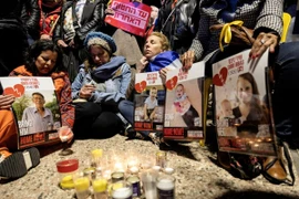 Người dân Israel cầu nguyện bên di ảnh gia đình con tin Bibas tại Tel Aviv, ngày 20/2/2025. (Nguồn: REUTERS/TTXVN)