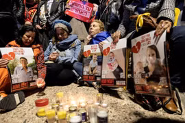 Người dân Israel cầu nguyện bên di ảnh gia đình con tin Bibas tại Tel Aviv, ngày 20/2/2025. (Nguồn: REUTERS/TTXVN)
