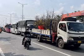 Dòng phương tiện phía tỉnh Bến Tre nối đuôi nhau nhích từng chút chờ qua cầu Rạch Miễu. (Ảnh: Công Trí/TTXVN) 