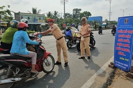 Hoạt động hỗ trợ người dân về quê ăn Tết của lực lượng cảnh sát giao thông. (Nguồn: Huỳnh Phúc Hậu/TTXVN)