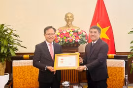 Thứ trưởng thường trực Bộ Ngoại giao Nguyễn Minh Vũ trao Kỷ niệm chương “Vì sự nghiệp ngoại giao Việt Nam” cho ông Choi Joo Ho, Tổng giám đốc Tổ hợp Samsung Việt Nam. (Nguồn: TTXVN)
