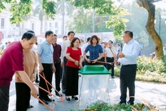 Lãnh đạo thành phố Hà Nội cùng công nhân môi trường của Công ty Đô thị Hà Nội tham gia dọn rác, làm vệ sinh môi trường khu vườn hoa và xung quanh Quảng trường Cách mạng Tháng Tám. (Ảnh: PV/Vietnam+)