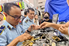 Cán bộ Cục Quản lý và Phát triển thị trường trong nước trực tiếp kiểm tra những "điểm nóng" về buôn lậu, hàng giả. (Ảnh: PV/Vietnam+)