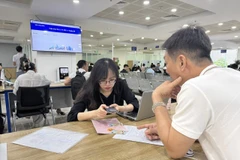 Người dân làm thủ tục về đất đai tại Trung tâm Phục vụ hành chính công Hà Nội. (Ảnh: Xuân Quảng/Vietnam+)