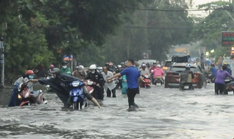 Nhiều tuyến đường ở Quận 2 ngập sâu khiến nhiều người dân khó di chuyển. (Ảnh: Hồng Giang/TTXVN)