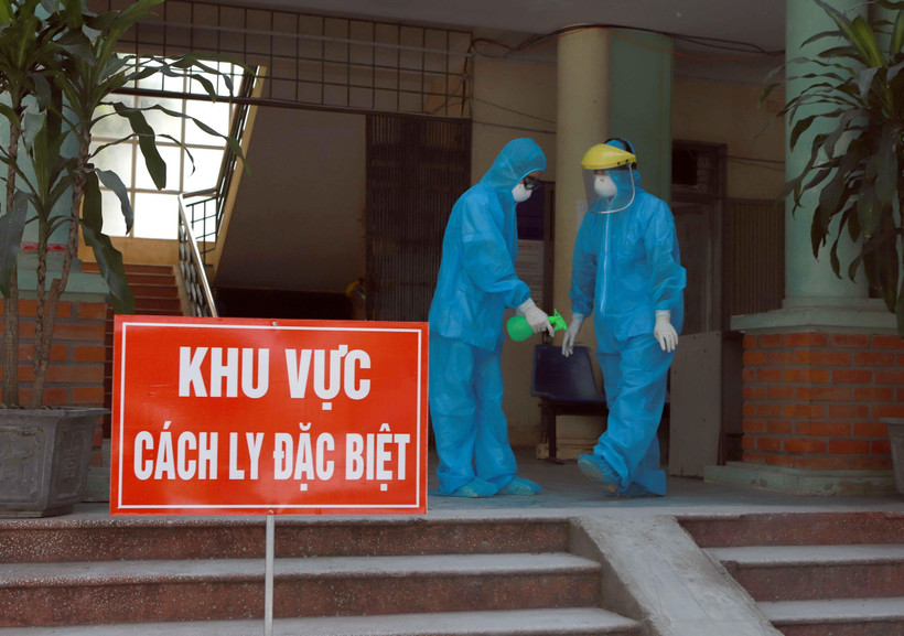 Các y bác sỹ Phòng khám Đa khoa khu vực Quang Hà mặc đồ bảo hộ và xịt nước xát khuẩn khi làm việc tại khu vực cách ly. (Ảnh: Hoàng Hùng/TTXVN)