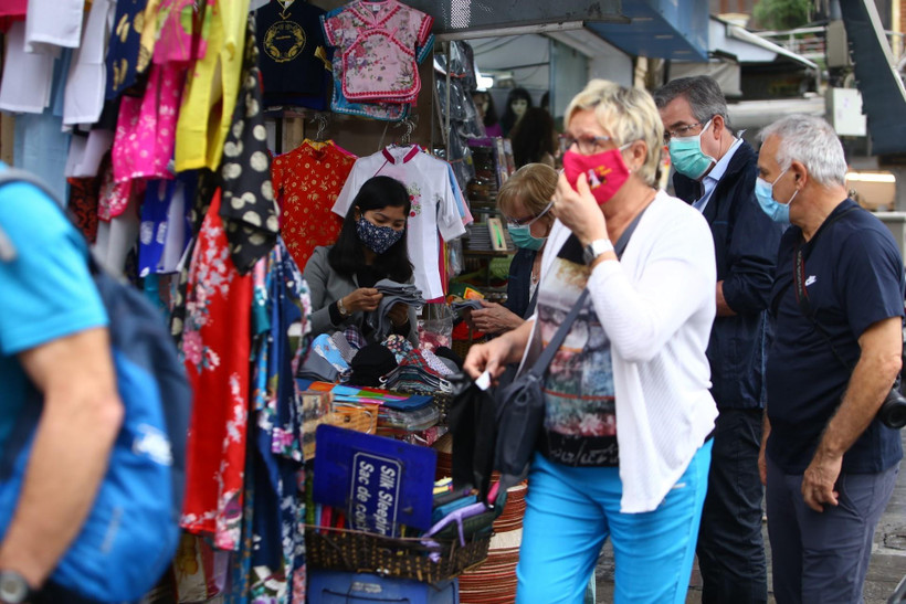 Khách du lịch nước ngoài đeo khẩu trang khi tham quan, mua sắm ở Việt Nam trong thời kỳ dịch COVID-19. (Ảnh: Minh Quyết/TTXVN)