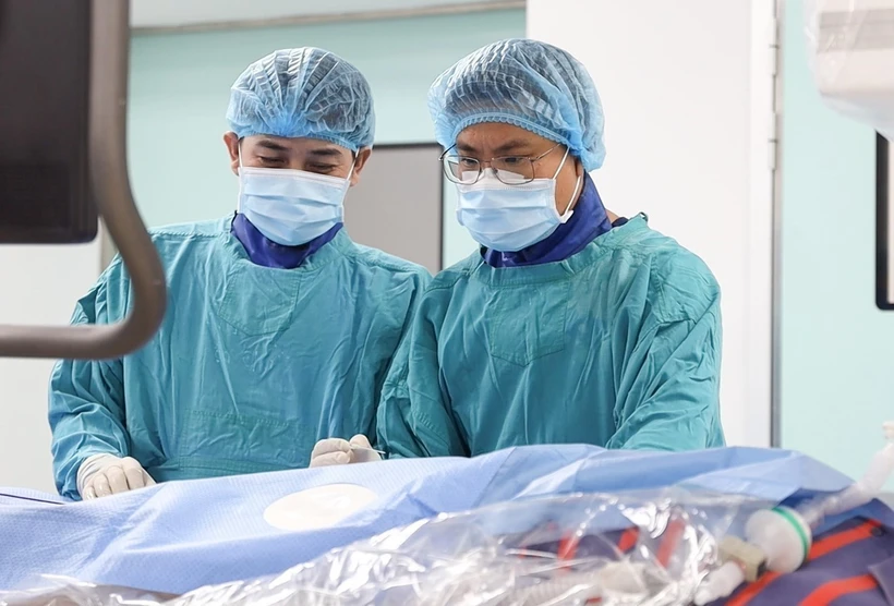 Các bác sĩ thực hiện hút huyết khối cho bệnh nhân. (Ảnh: TTXVN phát)