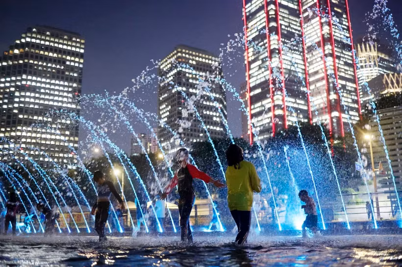 Trẻ em vui chơi dưới đài phun nước dọc sông Hàn ở Thủ đô Seoul (Hàn Quốc). (Ảnh: Yonhap/TTXVN)