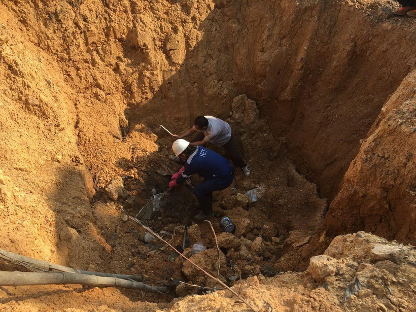 Hố chôn lấp chất thải đổ trộm có kích thước 2mx2m, chưa xác định được độ sâu, có chứa các chất màu trắng giống ximăng, có mùi hắc. (Ảnh: Mạnh Khánh/TTXVN)