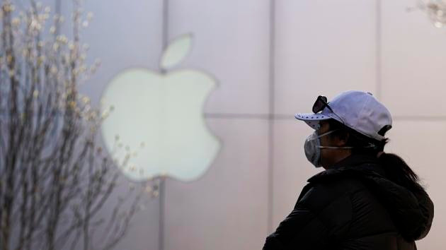 Một người dân đeo khẩu trang bên ngoài cửa hàng Apple ở Bắc Kinh, tháng 3/2020. (Nguồn: Getty Images)
