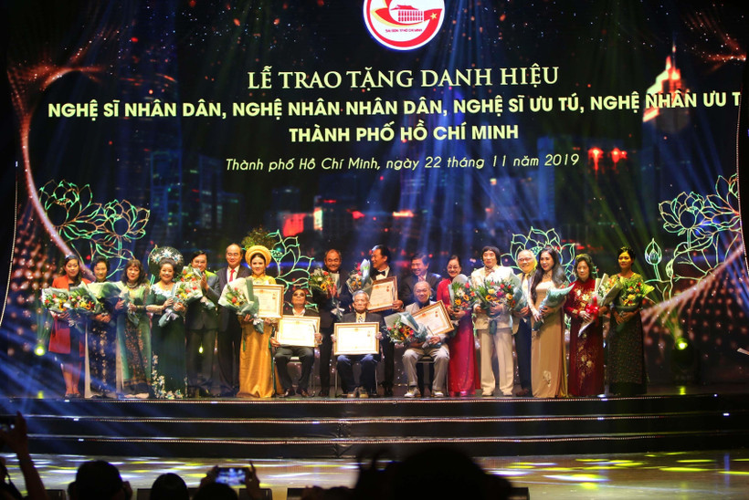 Bí thư Thành ủy Nguyễn Thiện Nhân và Chủ tịch Ủy ban Nhân dân Thành phố Nguyễn Thành Phong với các nghệ sỹ nhân dân được vinh danh. (Ảnh: Thanh Vũ/TTXVN)