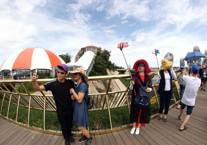 Khách du lịch chụp ảnh tại Cầu Vàng ở Khu du lịch Bà Nà Hills (Đà Nẵng). (Ảnh: Trần Lê Lâm/TTXVN)