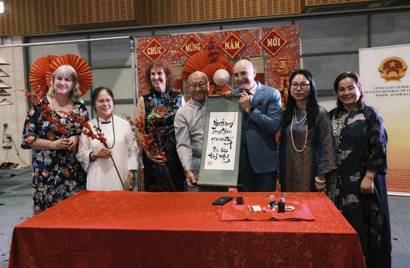 Thống đốc Vùng lãnh thổ Bắc Australia Hugh Heggie (thứ ba, phải) với bức thư pháp. (Ảnh: TTXVN phát)