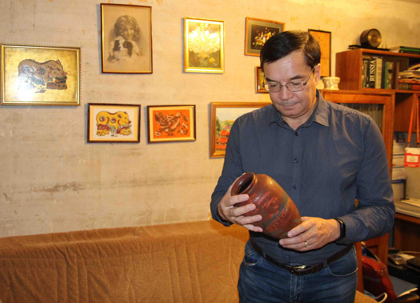 Anh Zhenya xem những kỷ vật gắn liền với đất nước Việt Nam. (Ảnh do nhân vật cung cấp/Vietnam+)