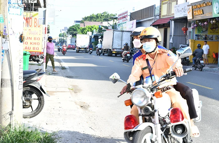 Thượng úy Hoàng Thế Minh chở thí sinh Võ Lâm Hùng đến điểm thi kịp thời. (Nguồn: Báo Kiên Giang)