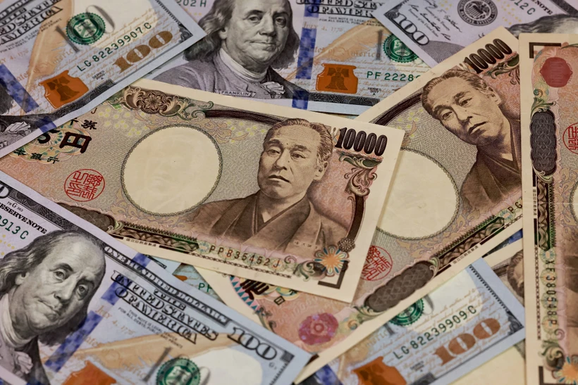 Đồng 10.000 yen và đồng 100 USD. (Ảnh: AFP/TTXVN)