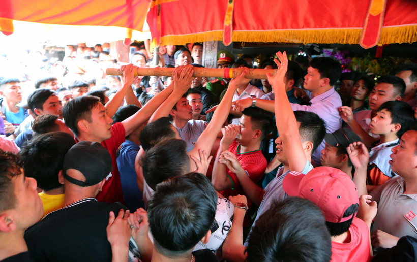 Người may mắn giằng được cây bông mang về đình làng. (Ảnh: Thành Đạt/TTXVN)