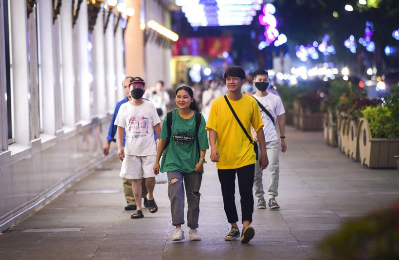 Các bạn trẻ thích thú với không khí trên phố đi bộ hồ Hoàn Kiếm ngày hoạt động trở lại sau thời gian tạm dừng hoạt động vì COVID-19. (Ảnh: Thành Đạt/TTXVN)